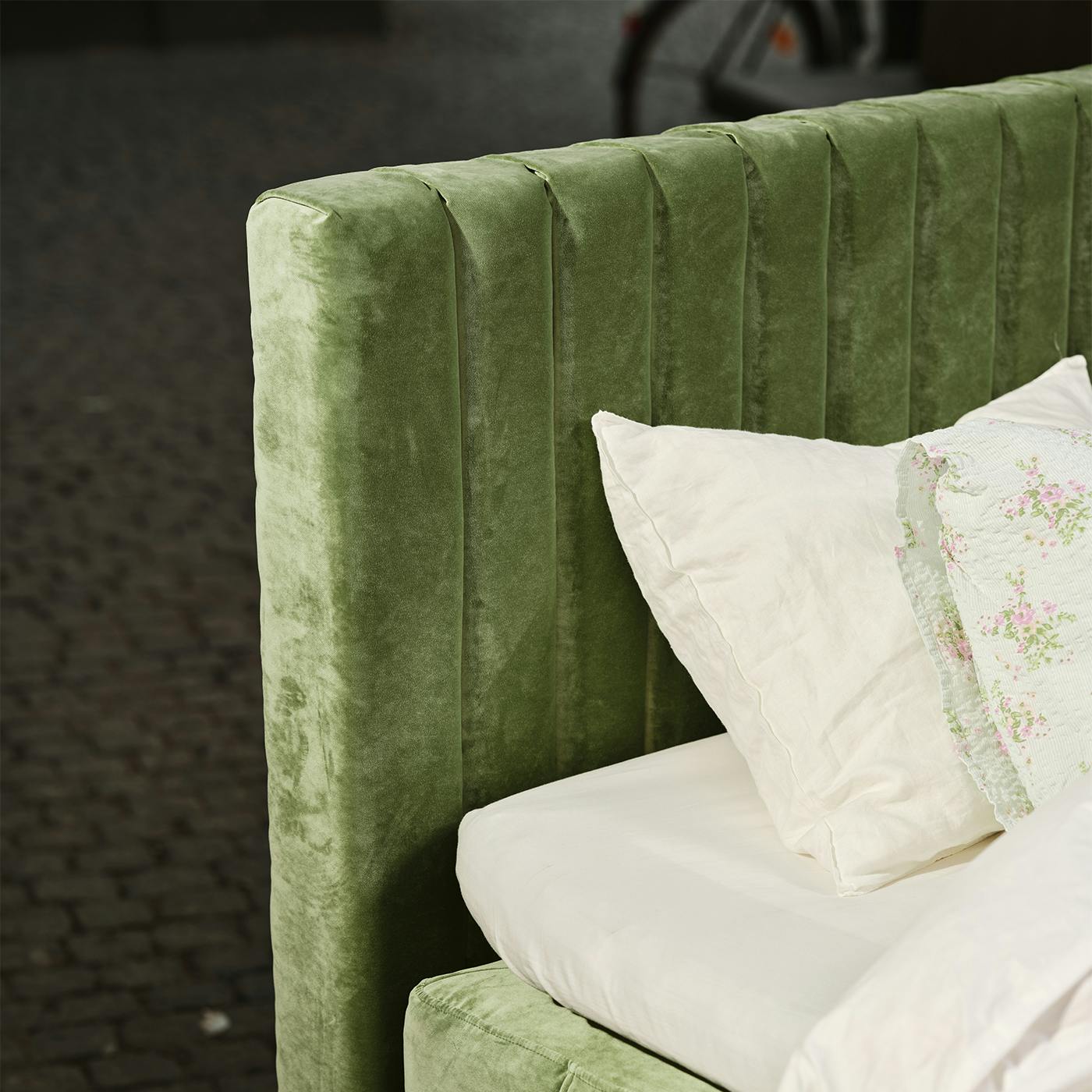 Ribbad sänggavel, 180cm bred, i en tålig grön polyestersammet. 