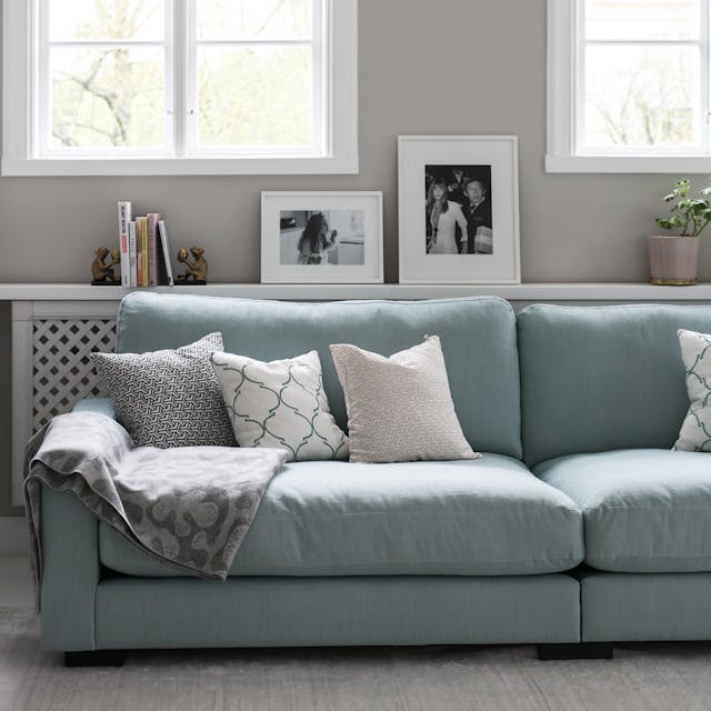 Blå soffa i manchester med djupa sittkuddar och höga ryggkuddar. 285cm bred soffa i dun och kallskum.