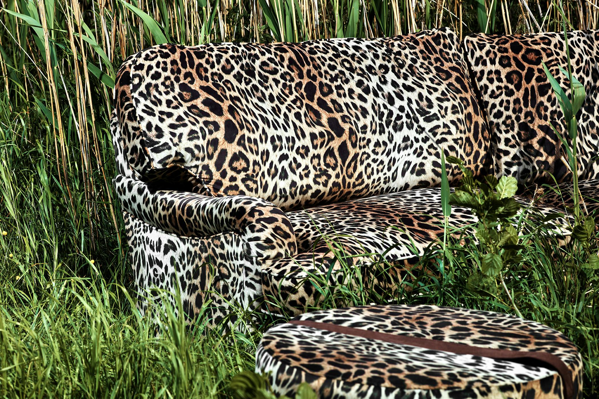 Svängd 3-sits howardsoffa med hög rygg, rundade armstöd och bekväma sittkuddar i leopardtyg. 
